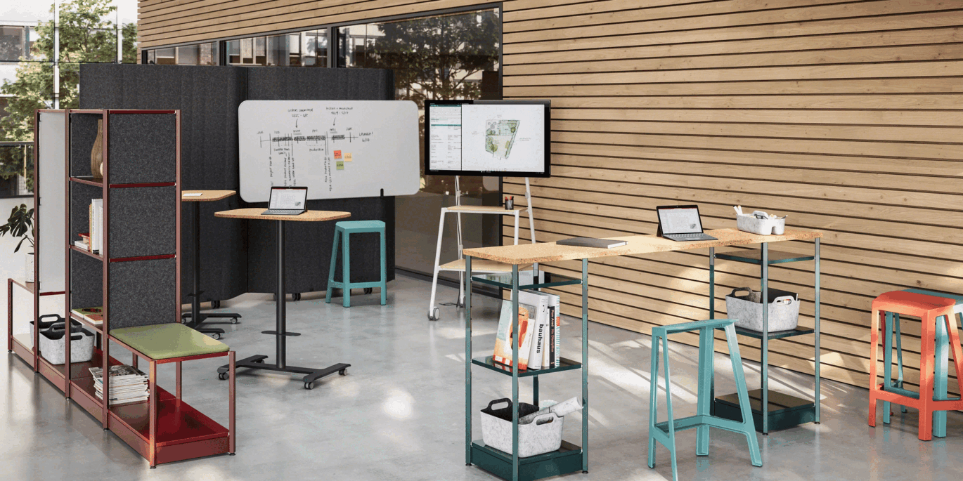 Innovatives Smart Office mit flexibler Büroeinrichtung, Stehtischen, Rolltafeln und Monitoren in einem modernen Raum mit Holzpaneelen und mobilem Arbeitszubehör.